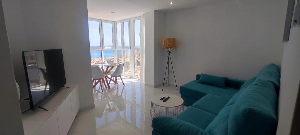 a living room with a blue couch and a television at Seaview By D. in Torrevieja