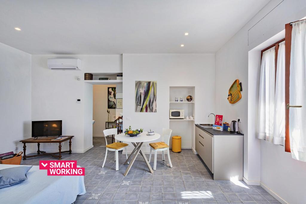 een keuken en een woonkamer met een tafel en stoelen bij Yellow Suite sul Lungomare di Recco by Wonderful Italy in Recco