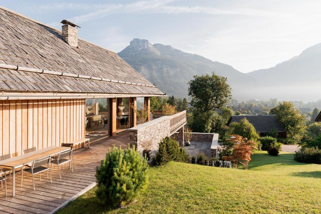 a house with a deck with mountains in the background at Villa Seeblick - Your Austrian Home in Altaussee