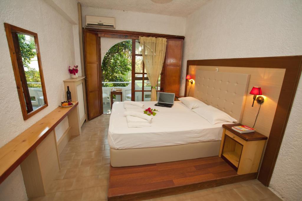a bedroom with a bed with a laptop on it at Damnoni Paradise in Damnoni