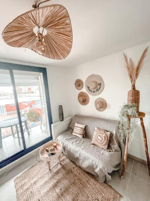 un salon avec un canapé et une grande fenêtre dans l'établissement La Casita ,Appartement face à l’étang, au Barcarès