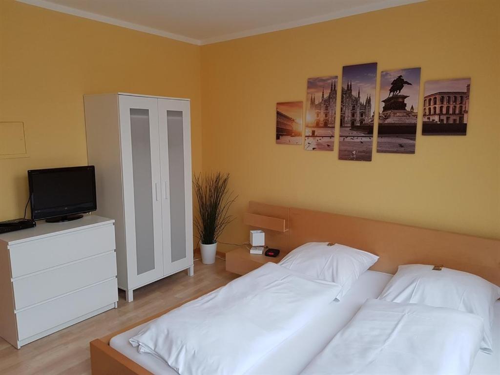 a bedroom with two beds and a flat screen tv at Nauwieser Apartments in Saarbrücken