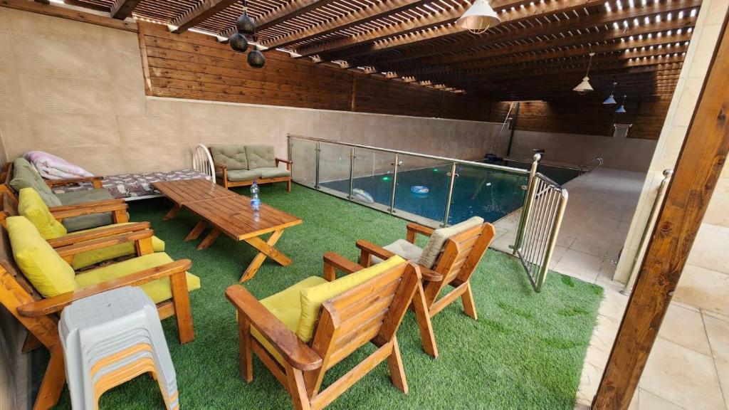 a patio with a table and chairs and a swimming pool at alzain villas - فلل الزين اريحا in Jericho