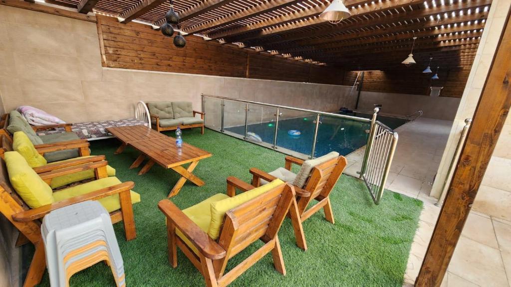 傑里科的住宿－alzain villas - فلل الزين اريحا，一个带桌椅的庭院和一个游泳池