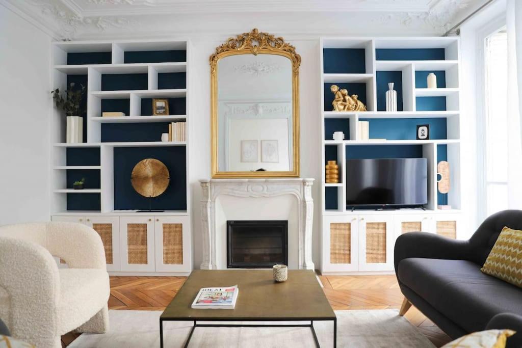 un salon avec une cheminée et un miroir dans l'établissement Charming 3 bedroom Haussmannien apartment in 17th, à Paris
