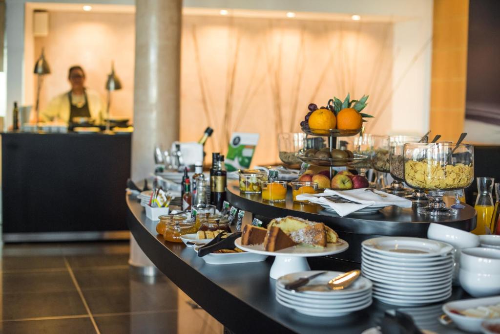 a buffet line with plates and food on it at Vila Gale Collection Praia in Albufeira
