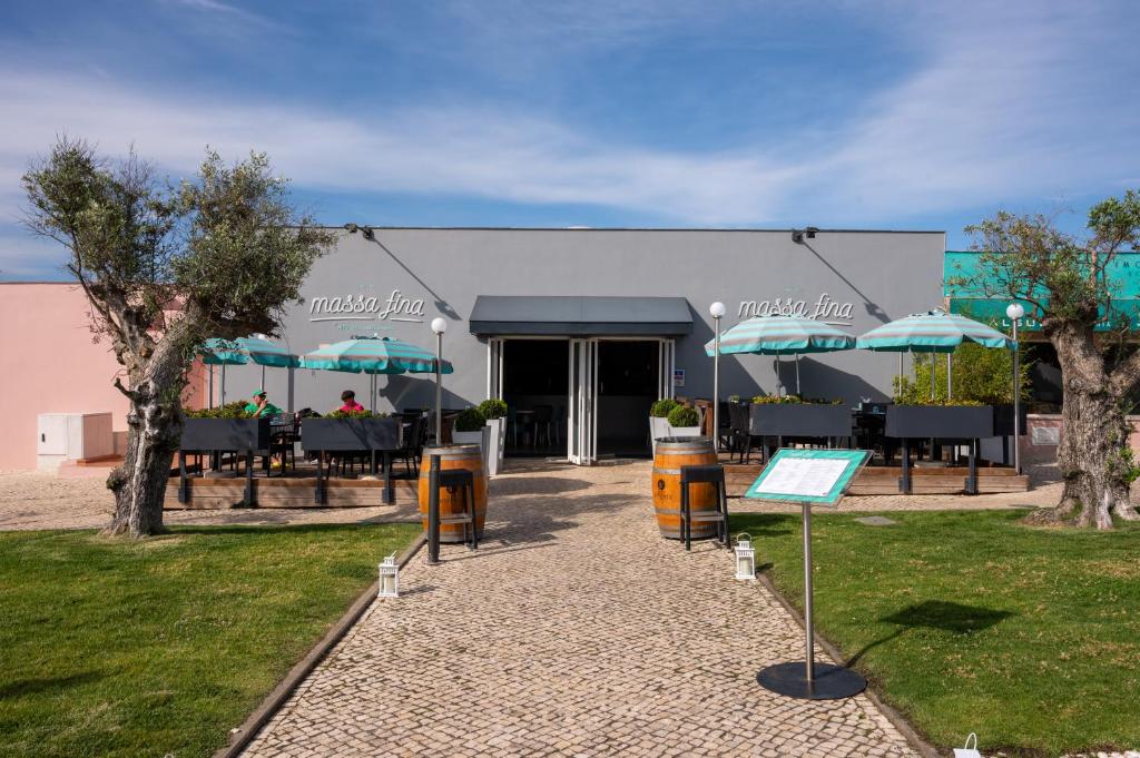 a restaurant with tables and umbrellas in front of it at Vila Gale Collection Praia in Albufeira