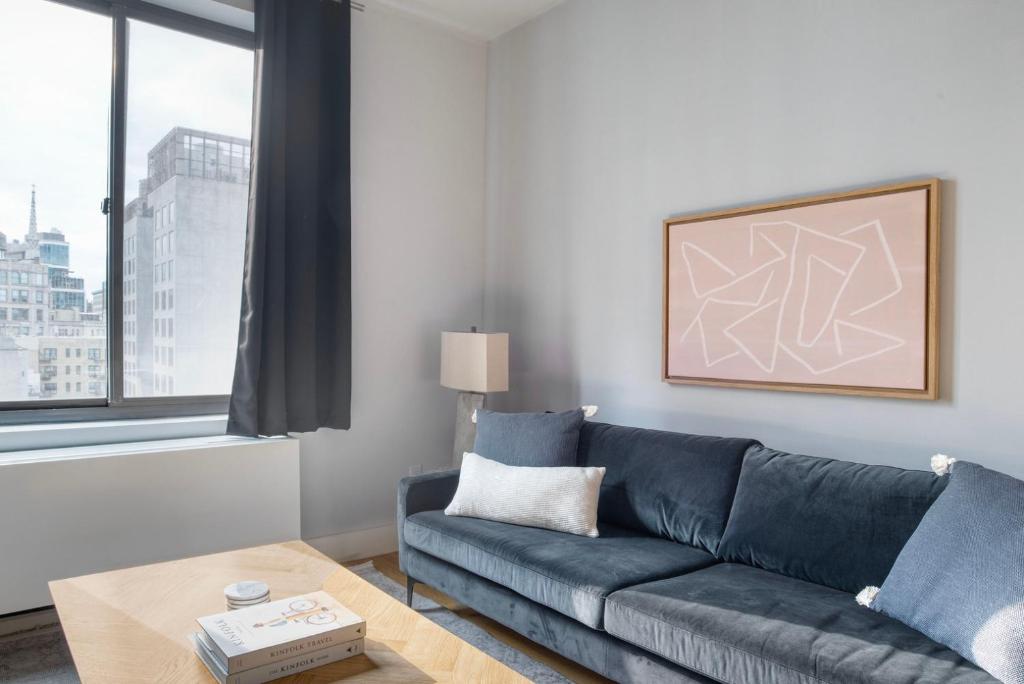 a living room with a blue couch and a table at East Village 1br w doorman wd nr Union Square NYC-1153 in New York