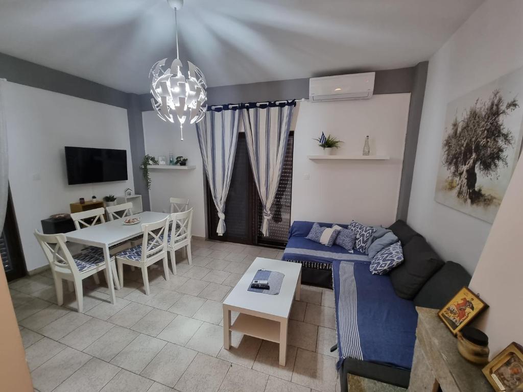 salon z niebieską kanapą i stołem w obiekcie Lucas Lux Flogita apartment w mieście Flogita