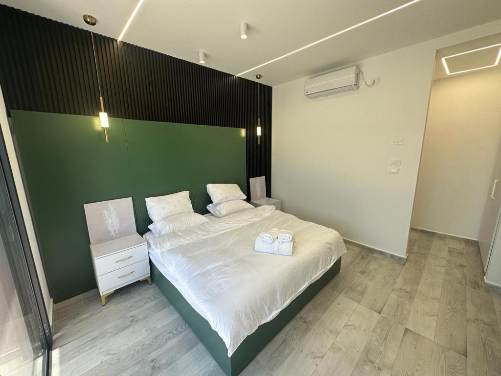 - une chambre avec un grand lit et un mur vert dans l'établissement  alzain 2 villas فلل الزين ٢, à Jéricho