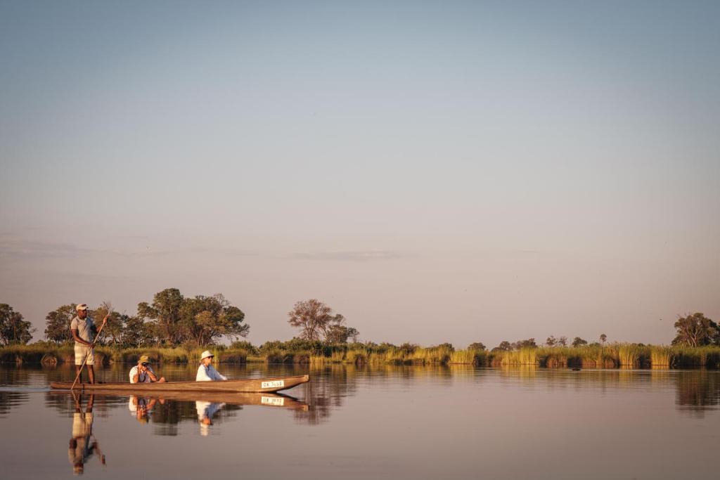 two people in a boat on the water at Cha Cha Metsi in Maun