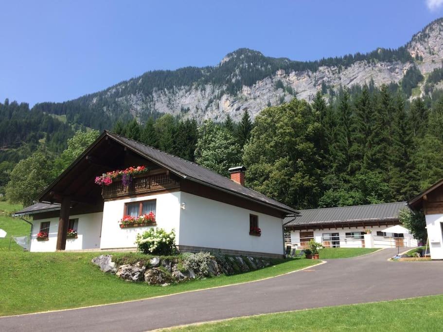 a white building with flowers in the window at Ferienwohnung Ingrid in Radmer an der Hasel