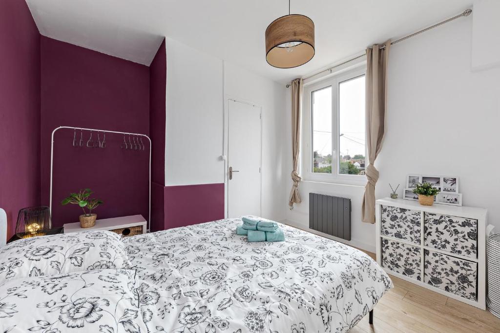 a bedroom with a bed and purple walls at L'Etape Relax in Saint-Étienne-du-Rouvray