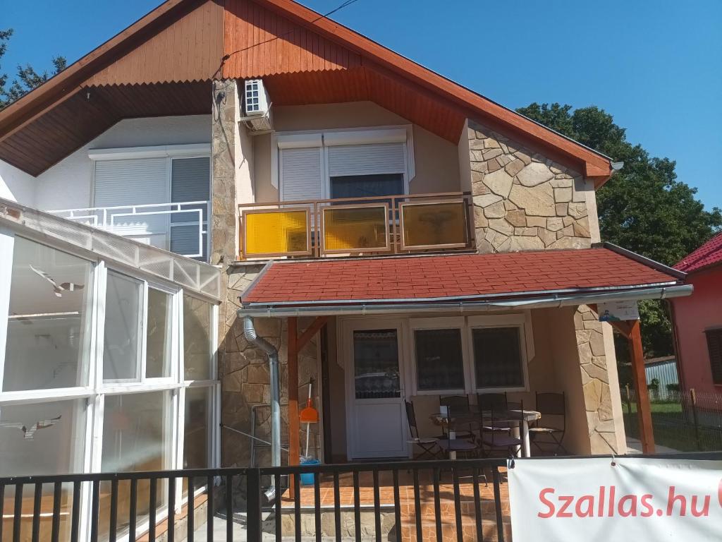 a house with a balcony and a patio at Napsugar Nyaraló in Fonyód