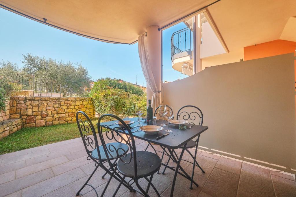 un tavolo nero e sedie su un patio di ApartmentsGarda - Corte Sant'Andrea a Lazise