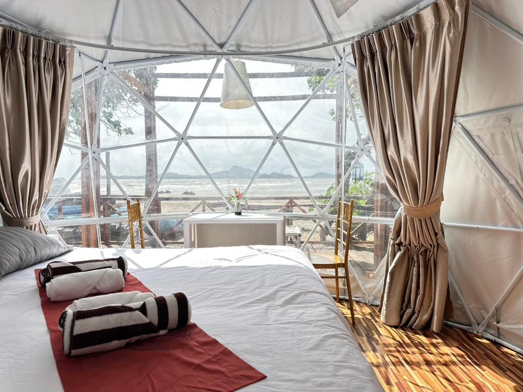 a bed in a room with a large window at 7 Heaven camping Lanta in Krabi town