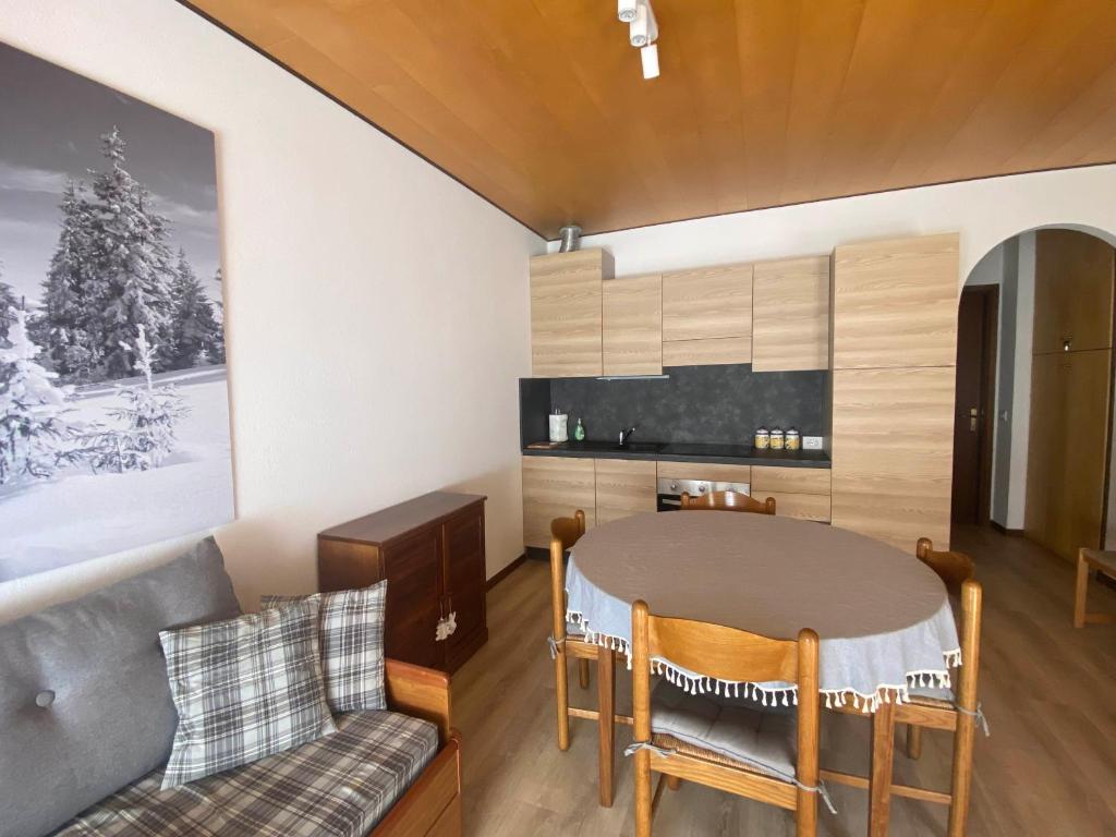 uma sala de estar com uma mesa e um sofá em Casa Monte Zebio em Asiago