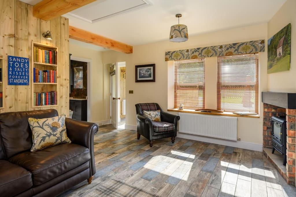 a living room with a couch and a fireplace at Country Cottage by St. Andrews in St Andrews