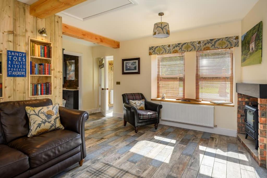 uma sala de estar com um sofá e uma lareira em Country Cottage by St. Andrews em St Andrews