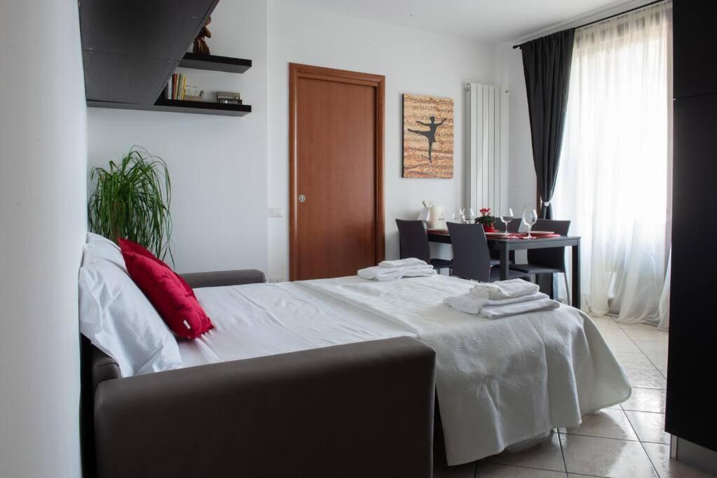 a bedroom with a white bed with red pillows on it at Bella Ciao Airport Apartment in Seriate