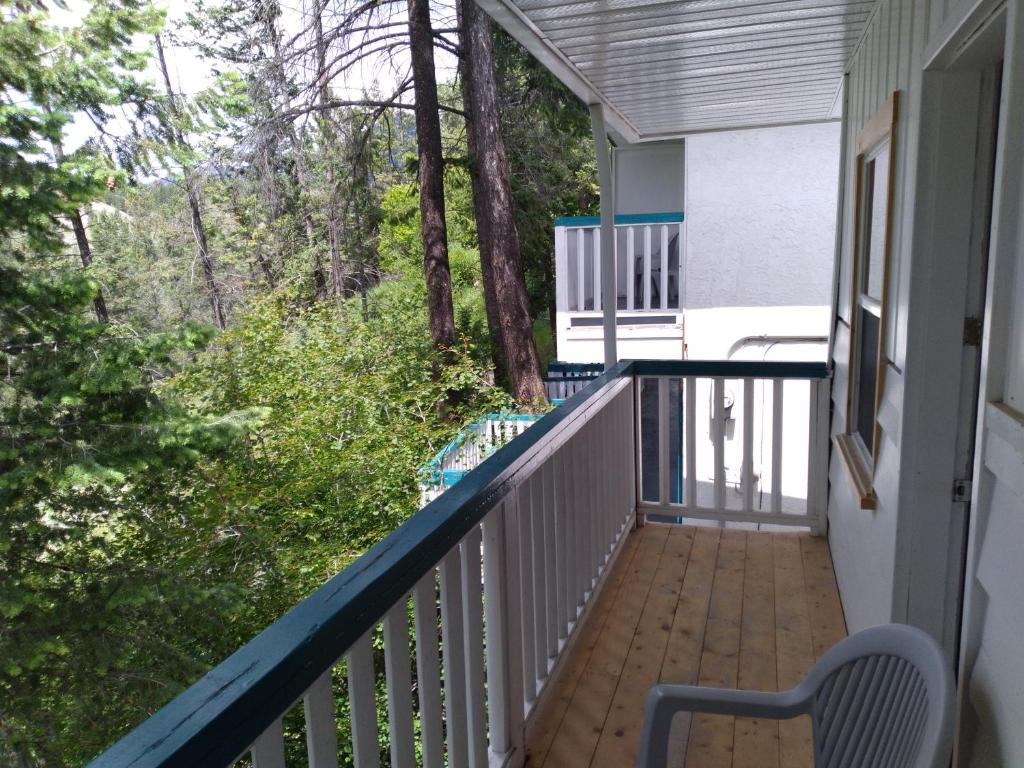 un balcón de una casa con un banco y árboles en AppleTree Inn, en Radium Hot Springs
