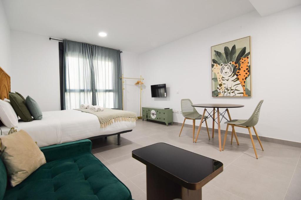 1 dormitorio con 1 cama, mesa y sillas en Letmalaga Gazules, en Málaga
