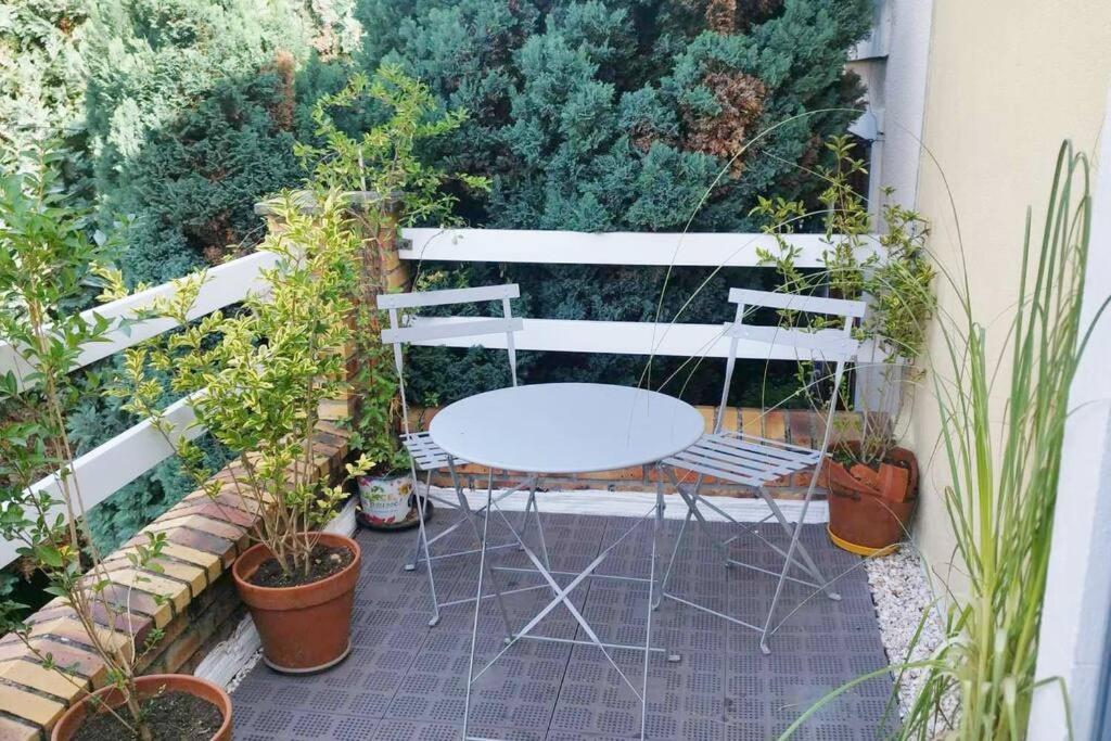 a table and chairs on a patio with plants at Maison atypique avec garage 2 roues - Proche Gare in Le Havre