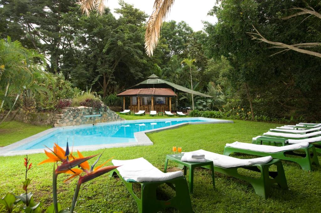 un grupo de sillas y una piscina con cenador en Dik Dik Hotel, en Arusha