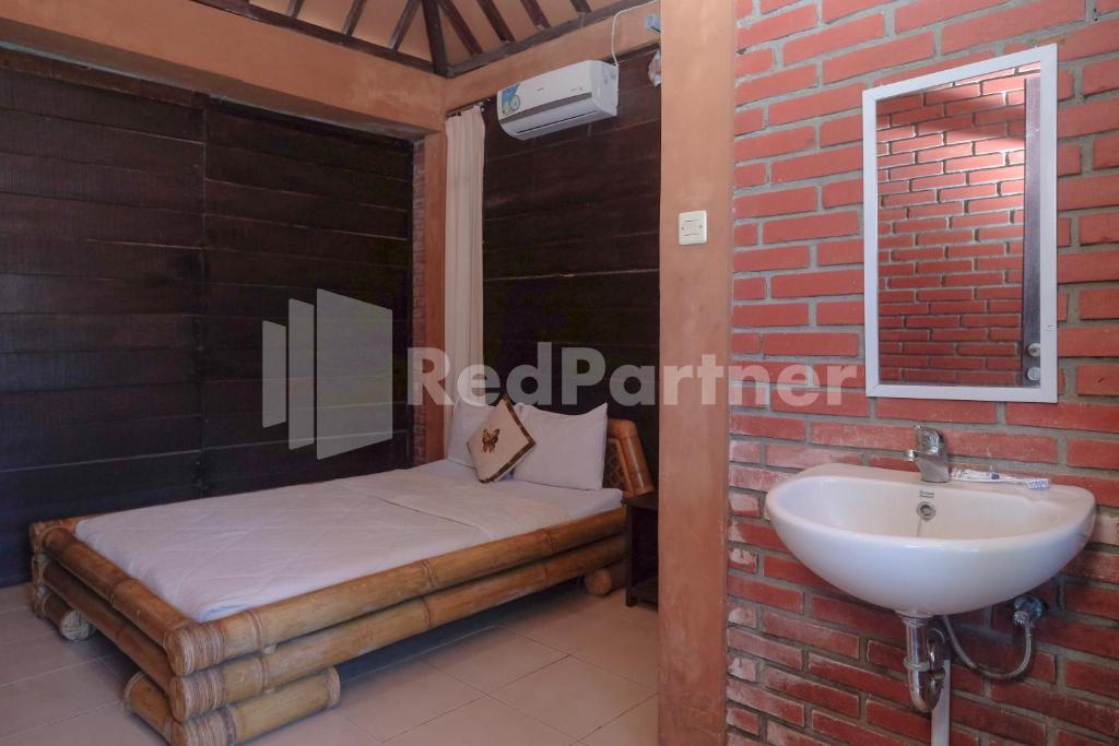 Postel nebo postele na pokoji v ubytování Kebon Krapyak Cottage Syariah Mitra RedDoorz near Stadion Maguwoharjo