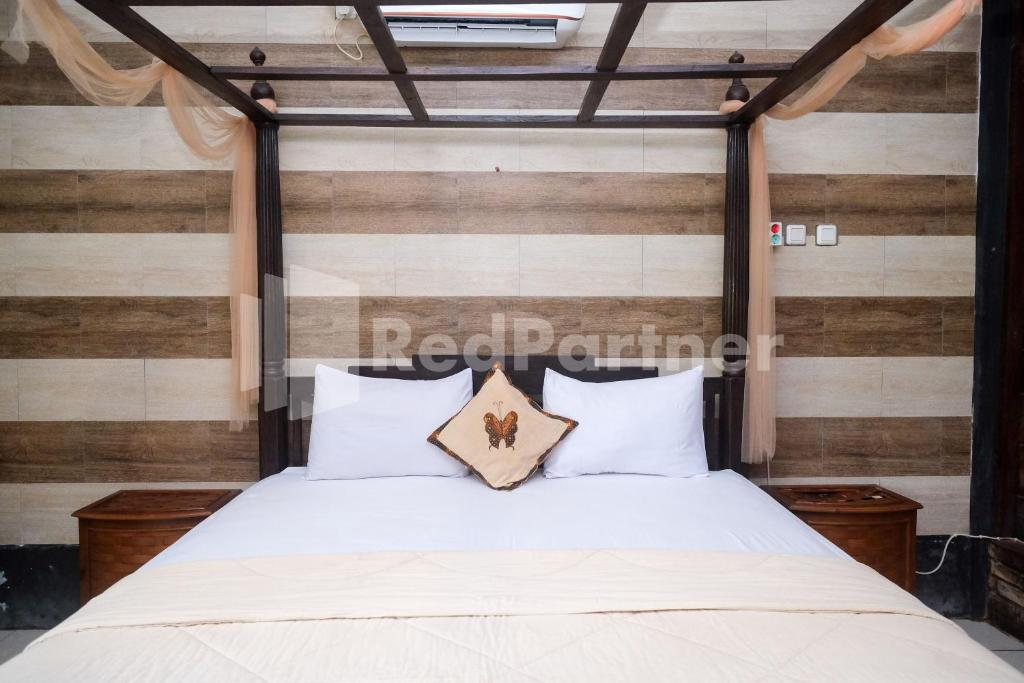 Postel nebo postele na pokoji v ubytování Kebon Krapyak Cottage Syariah Mitra RedDoorz near Stadion Maguwoharjo