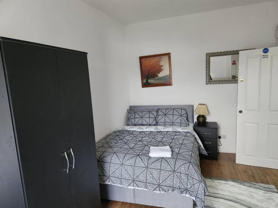 ein Schlafzimmer mit einem Bett und einem schwarzen Schrank in der Unterkunft Double room in Stone in Kent