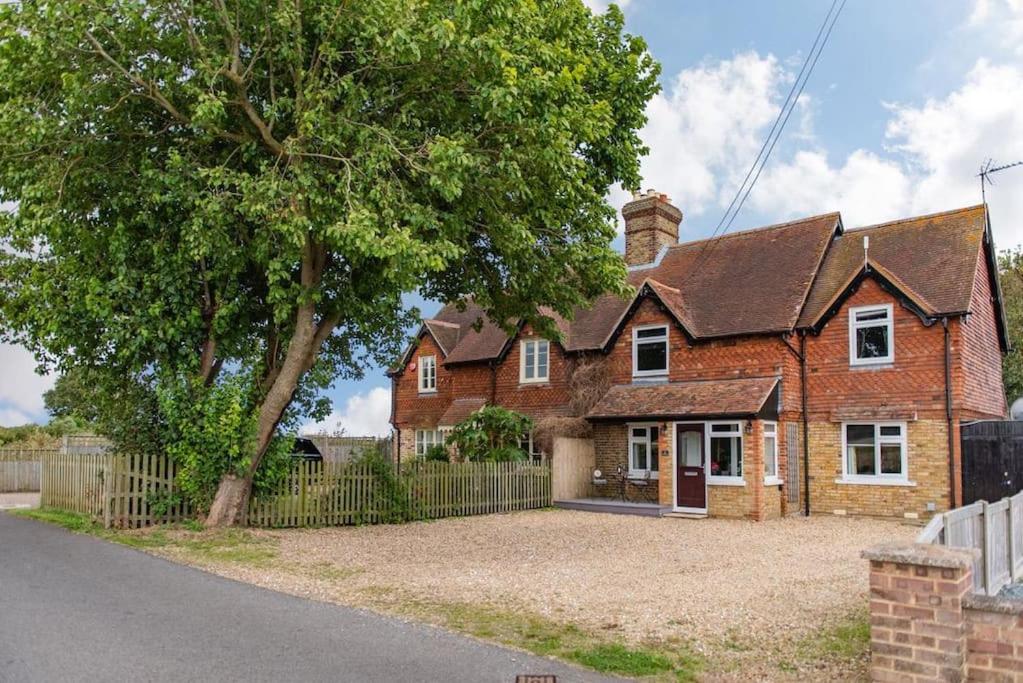 a brick house with a tree and a fence at Worth Cottage - Perfect for families & friends in Worth