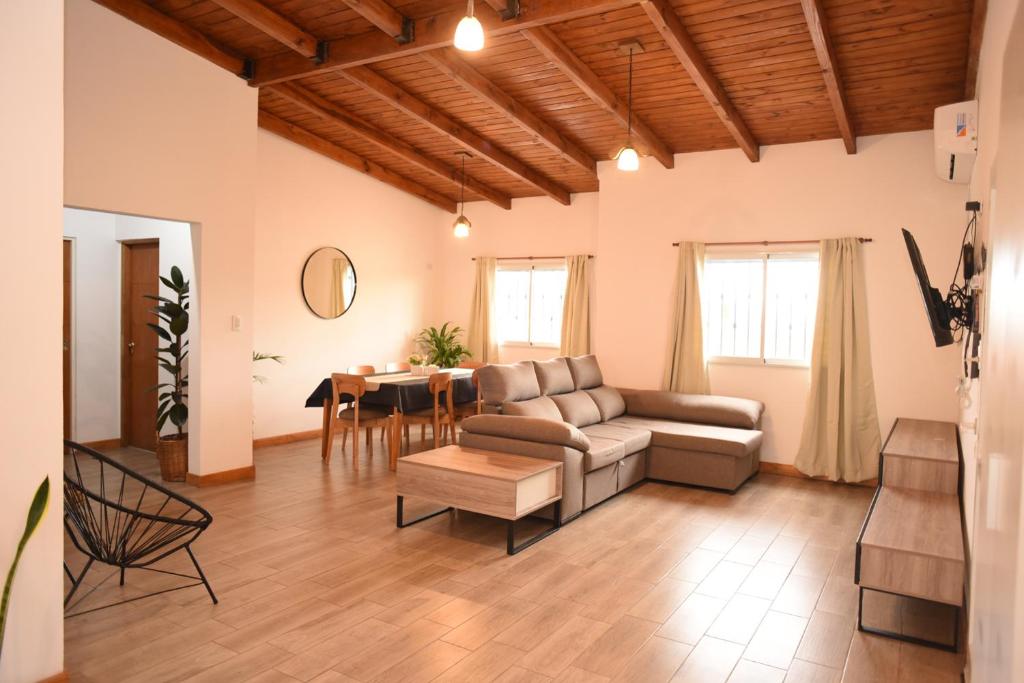 ein Wohnzimmer mit einem Sofa und einem Tisch in der Unterkunft Cozy House in San Nicolás de los Arroyos