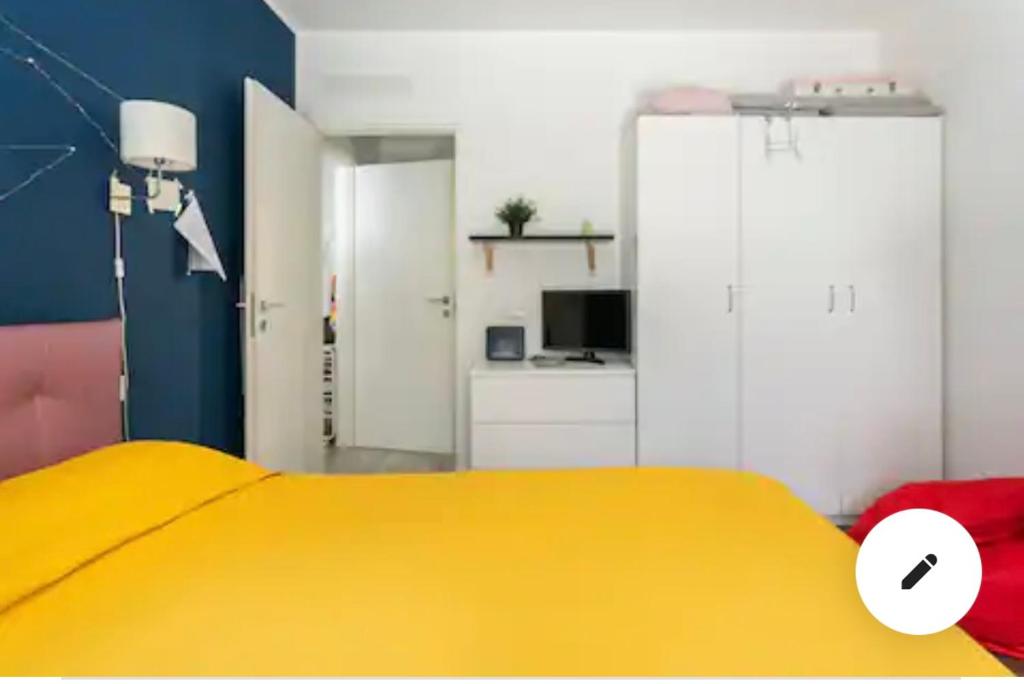 a bedroom with a yellow bed and a desk at Green Suite Pavia in Pavia