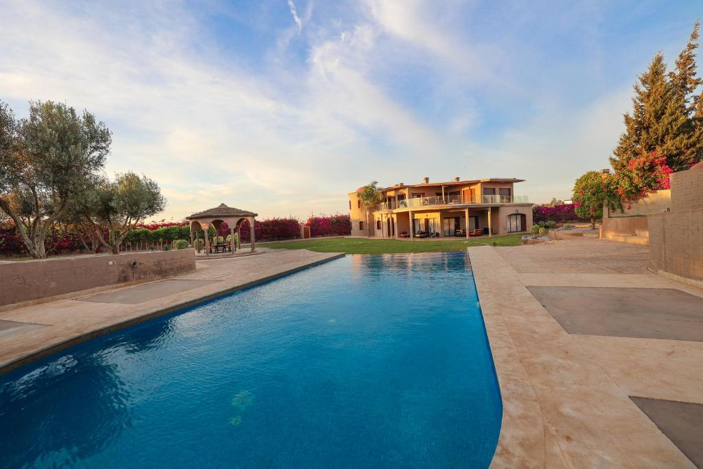 AÃ¯n el Ksob的住宿－Villa Tizra - guest house，房屋前有游泳池的房子