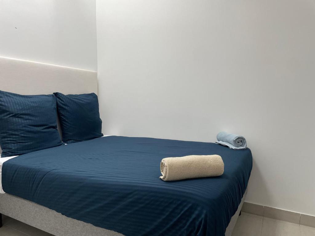uma cama com lençóis azuis e uma toalha em T2 Proximité La Défense em Colombes