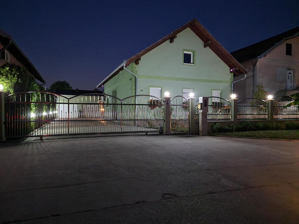 una casa con un cancello di fronte ad essa di notte di Boletova kuća na dan a Rumenka