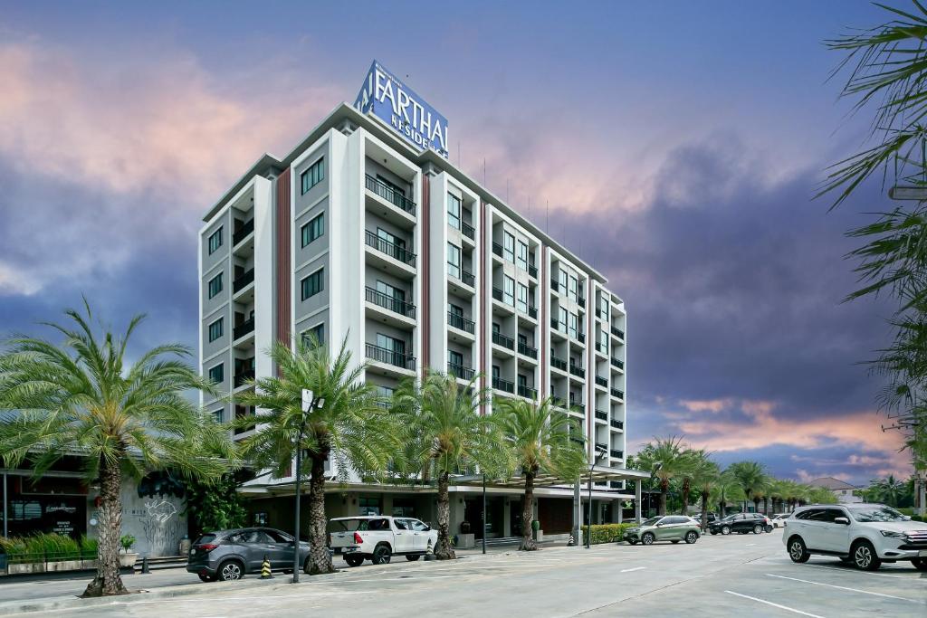 Farthai Residence في Phan Thong: مبنى الفندق يوجد عليه لافته