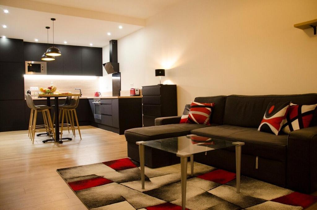 uma sala de estar com um sofá e uma mesa em Bel appartement moderne avec patio à Saint-Michel (Bordeaux) em Bordéus