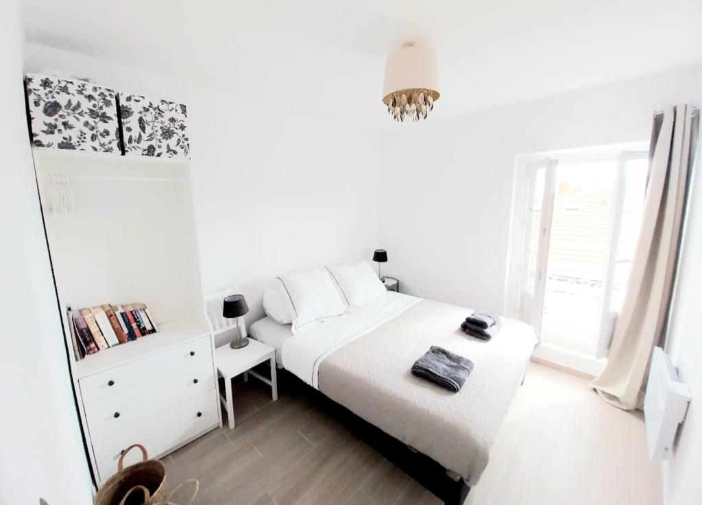 een witte slaapkamer met een bed en een spiegel bij Artists Apartment Montpellier-Place de la Comédie in Montpellier
