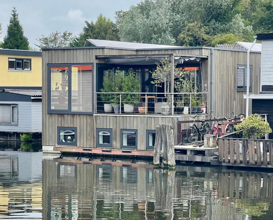 una casa en un muelle sobre un cuerpo de agua en NOVA Houseboat DELUXE Free Bikes, en Ámsterdam