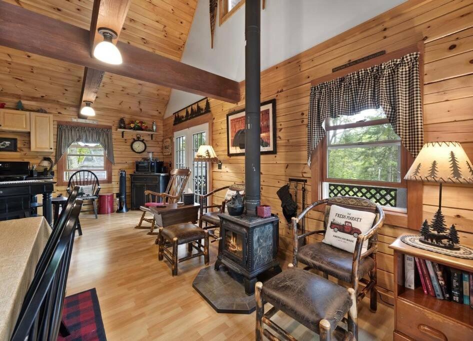 uma sala de estar com um fogão a lenha numa cabina em Rustic White Mountain Log Cabin Retreat! em Rumney