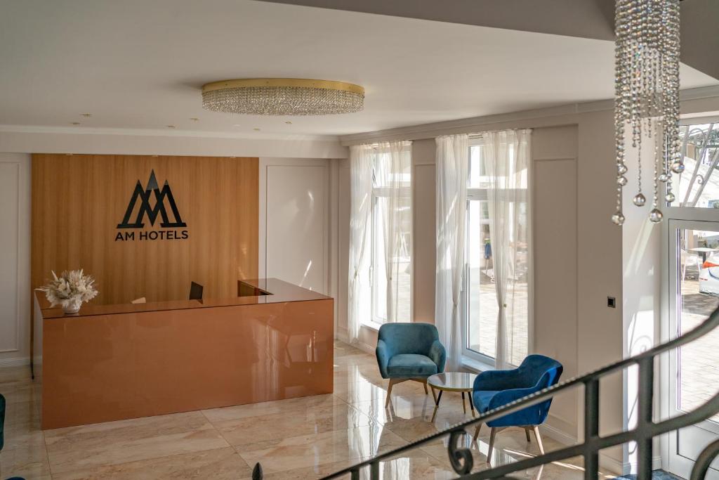 eine Lobby mit Stühlen und ein Schild in einem Gebäude in der Unterkunft AM HOTEL WELLNESS **** in Rimavská Sobota