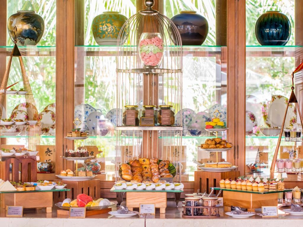 A brightly lit display presents pastries, fruit, jars and sweets.