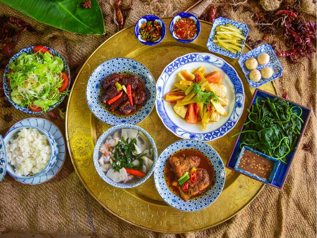 A generously arranged Vietnamese-style meal served in blue-and-white bowls.