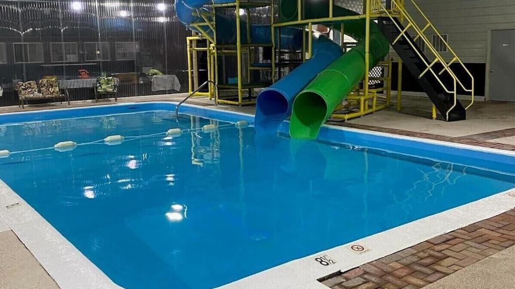a large swimming pool with a slide in it at Camp Inn Lodge in Au Sable