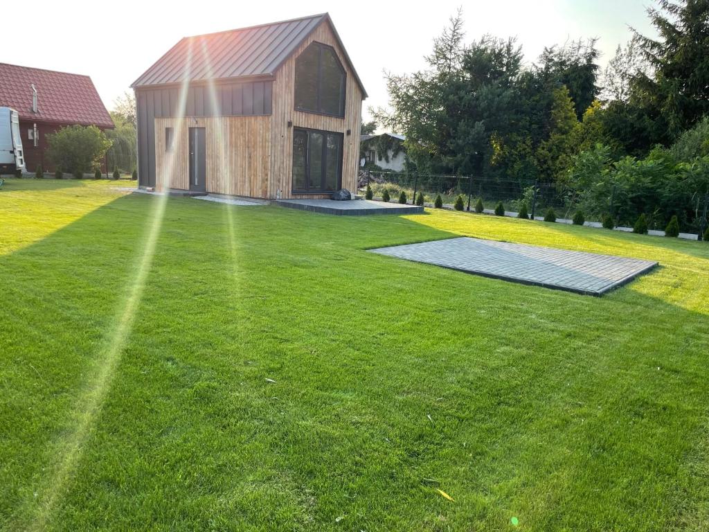 a house on a lawn with a solarium at Zielona Ostoja - domek z prywatnym pomostem przy Obrzycy in Kolsko