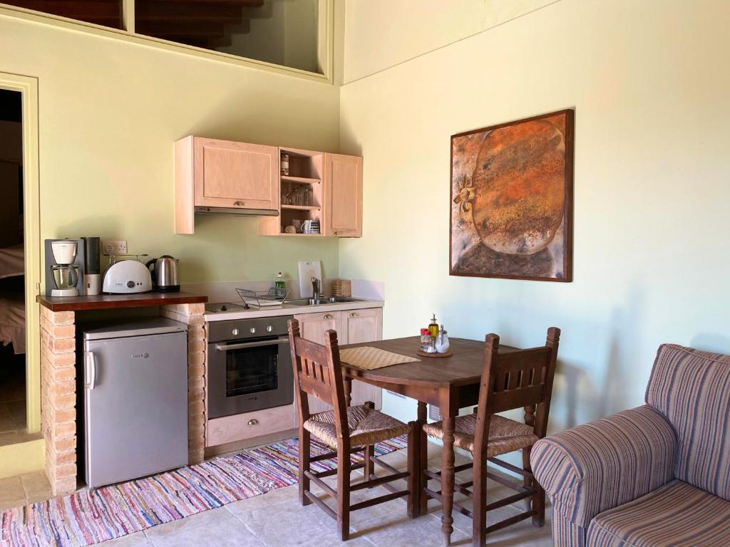 a kitchen with a table and a couch and a table and chairs at Eveleos Country House in Tochni