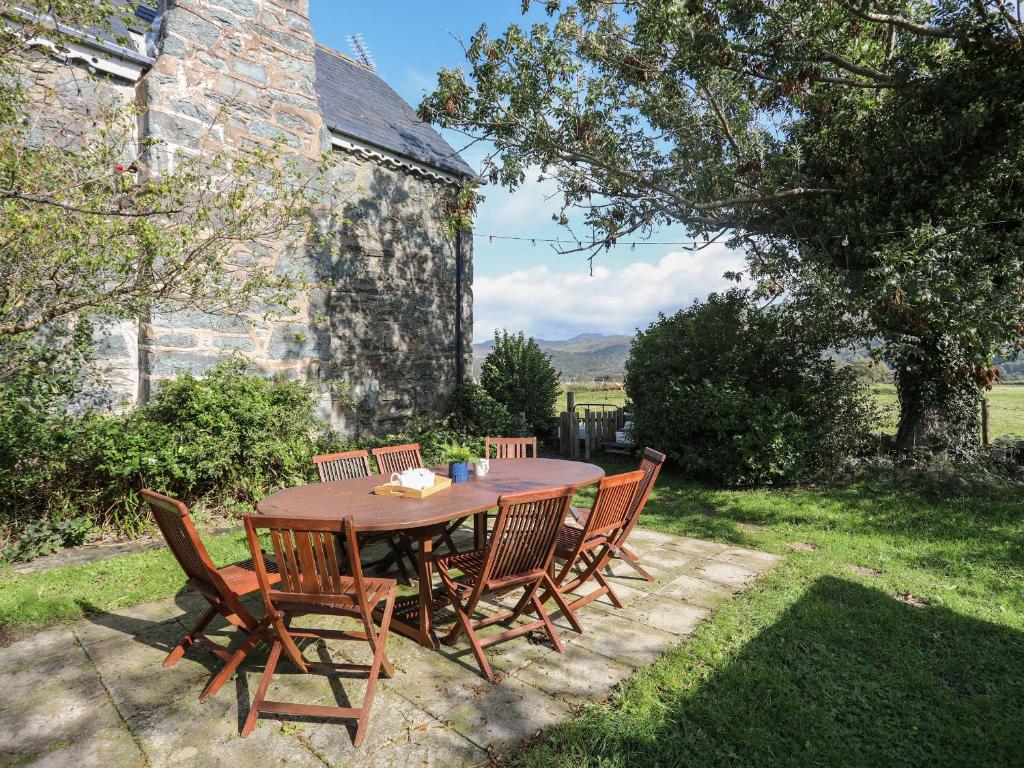 a wooden table and chairs in a yard at Glyn Morfa in Harlech