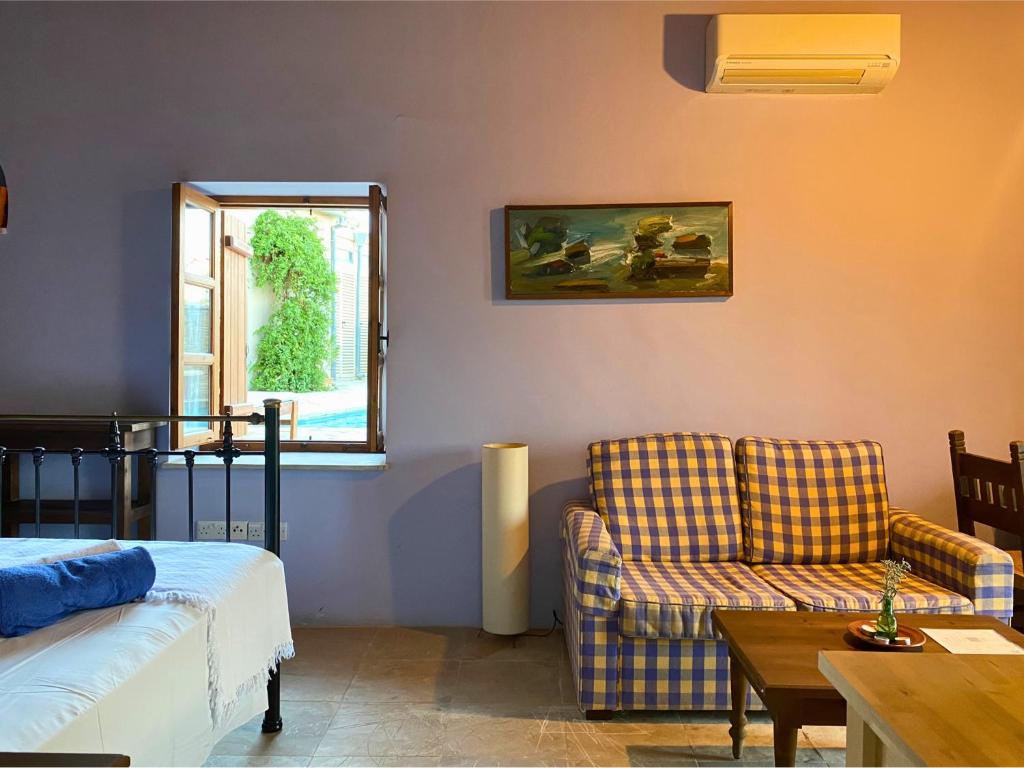 a room with a bed and a couch and a table at Eveleos Country House in Tochni